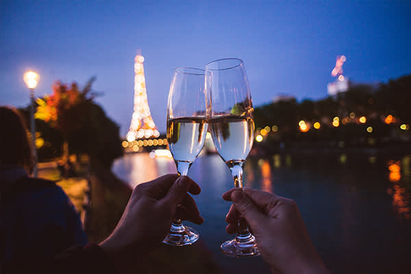 Clinking champagne flutes in paris at night