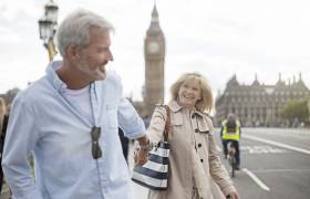 Smiling couple walking on Westminster Bridge