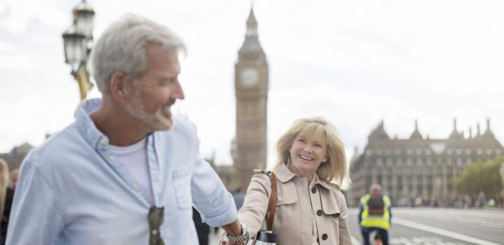 Smiling couple walking on Westminster Bridge