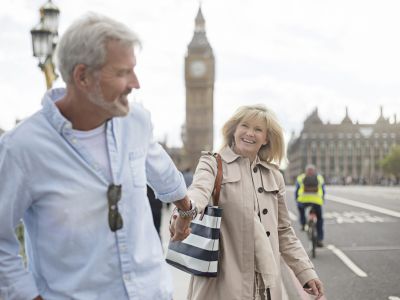 Smiling couple walking on Westminster Bridge